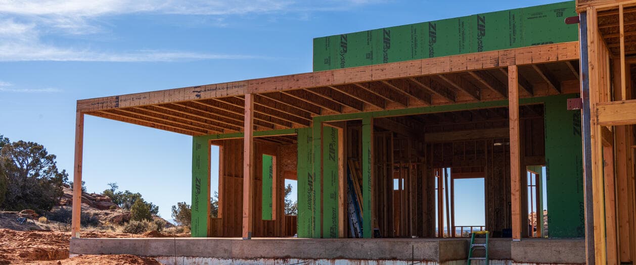 A Hammer and Hand Homes framing job outside Moab, Utah - exposed rafters over a covered porch with red rock beyond